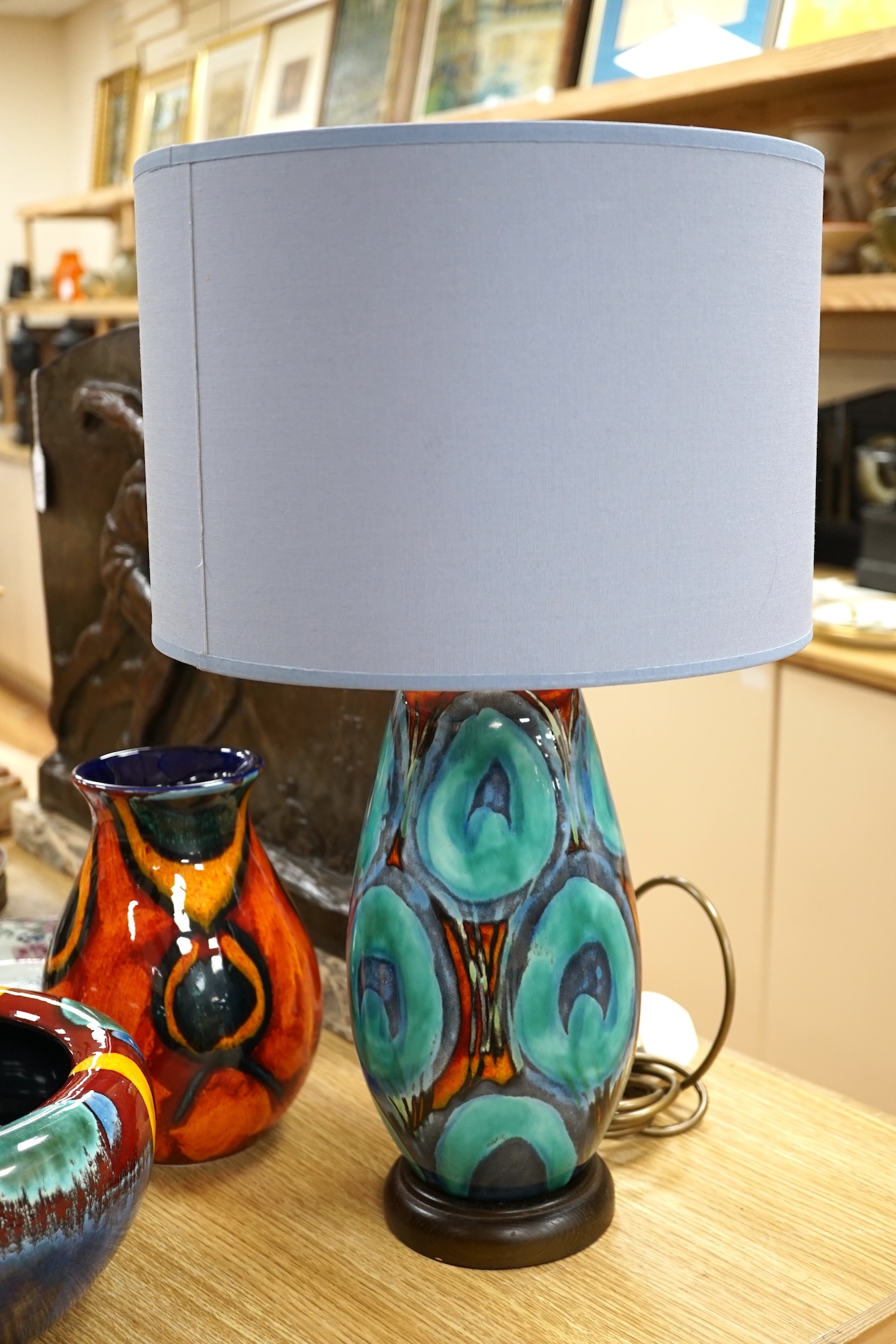 Three pieces of Poole pottery comprising Infusion concave bowl, a peacock design vase and a table lamp with shade, largest 51cm high. Condition - good